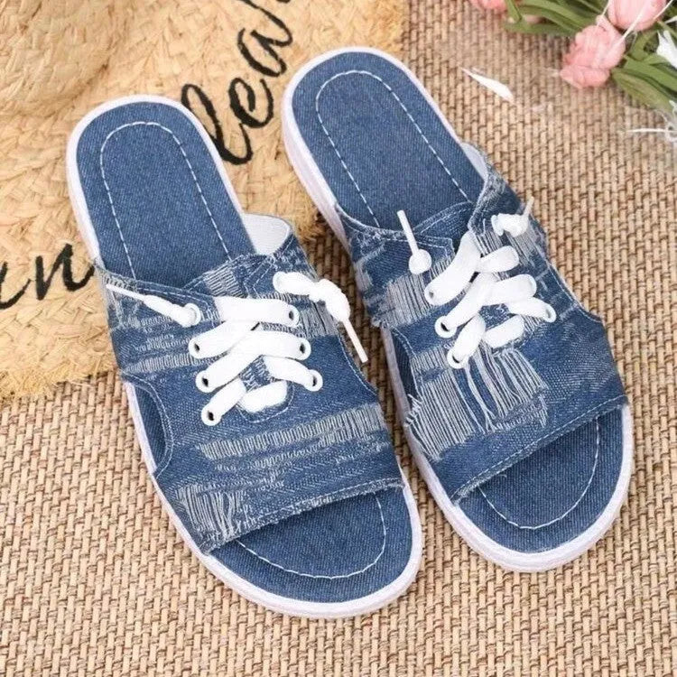 Blue women's flat canvas Roman style slippers with cloth upper and rubber sole.