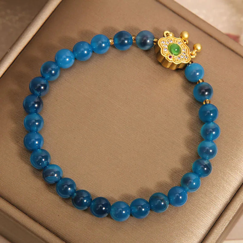 Blue sugar heart agate and jade safety lock pendant on a women's crystal bracelet with alloy inlay.