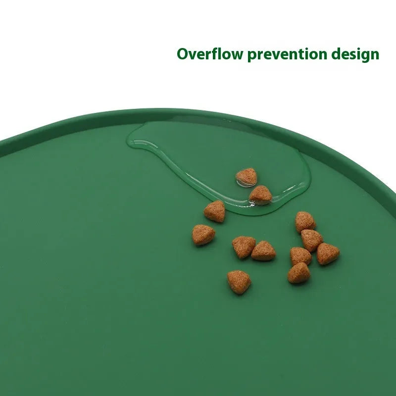 Green silicone cat feeding placemat with food and water bowls on a wooden floor