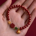 Happy Eyebrow bracelet made of raw Emperor Sandstone beads with a red Cinnabar and fu character charm.