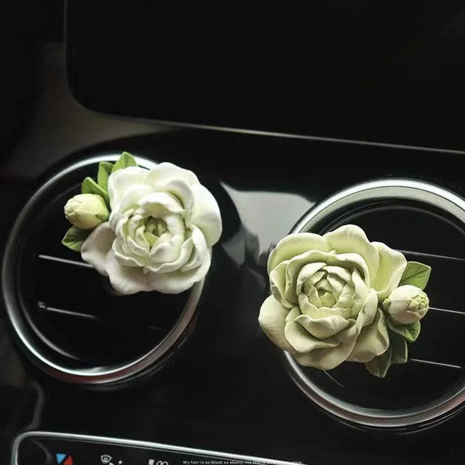 Jasmine solid car perfume gypsum tablet clipped to a car air vent.