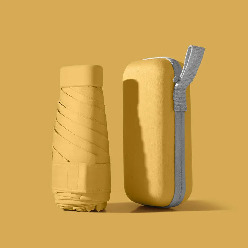 Six-fold manual umbrella in sky blue with capsule box storage, showing compact folded size and rubber handle
