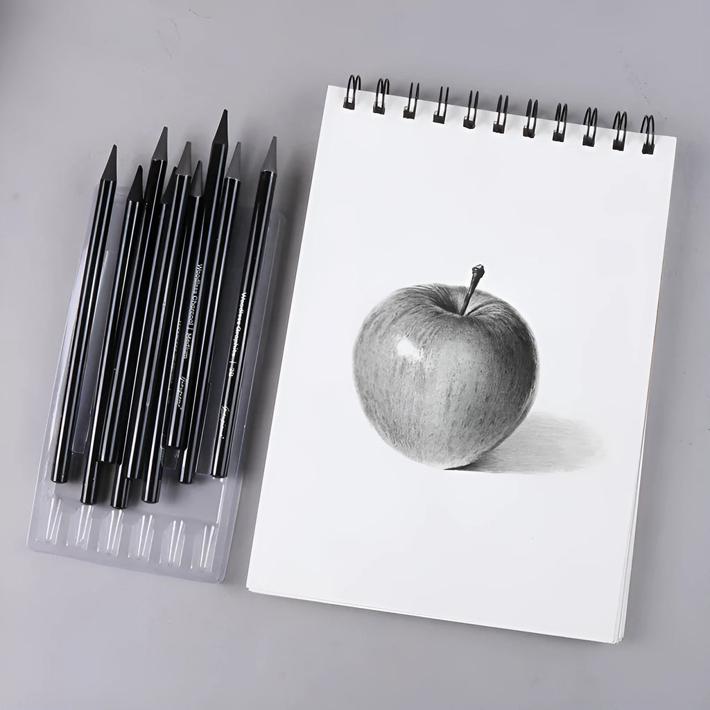 Set of nine art pencils on a card: six graphite pencils and three darker carbonized pencils in wooden casings.