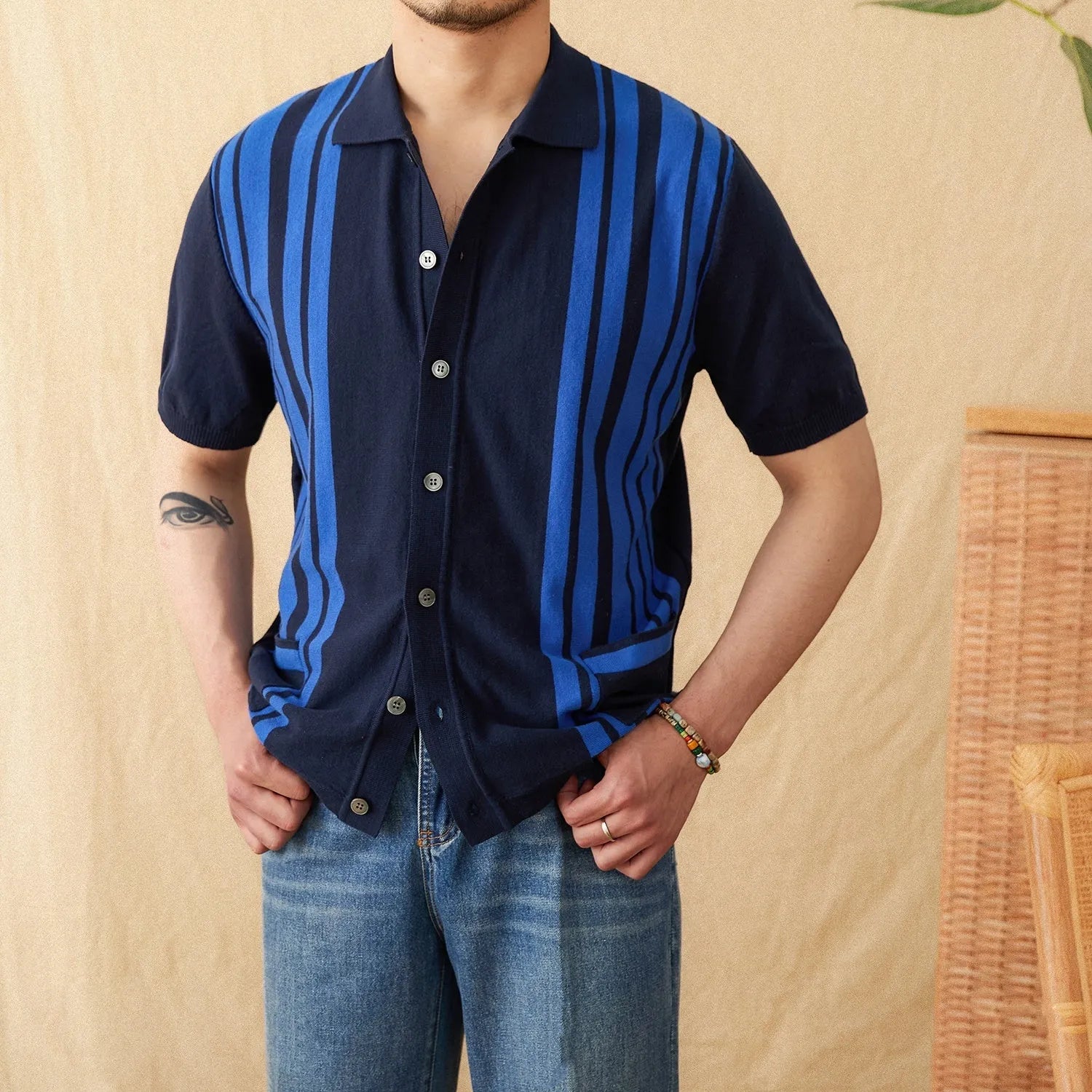 Man wearing a royal blue striped short-sleeved cardigan polo shirt with a lapel collar.