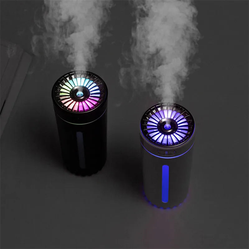 Black portable car humidifier with colourful LED lights showing mist output, placed in vehicle cup holder