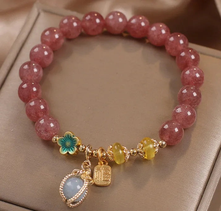 Red women's bracelet with natural strawberry quartz beads, alloy metal chain, and rhinestone details.