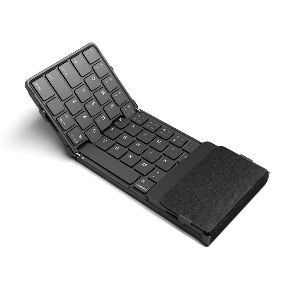 Black folding Bluetooth keyboard with touchpad unfolded next to mobile phone