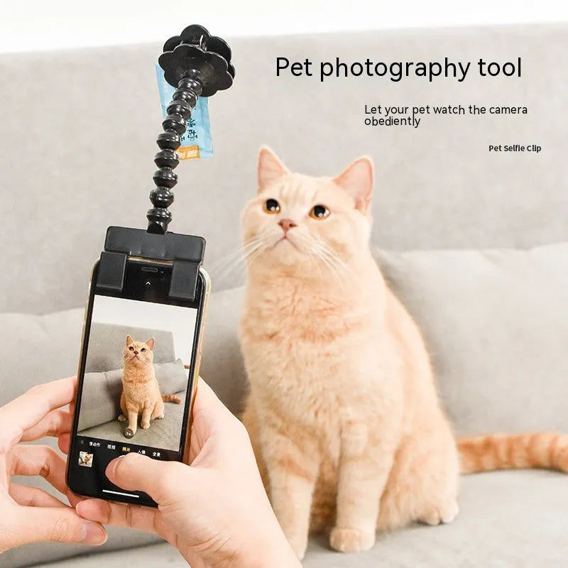 Black pet photography clip with rotating treat holder attached to mobile phone