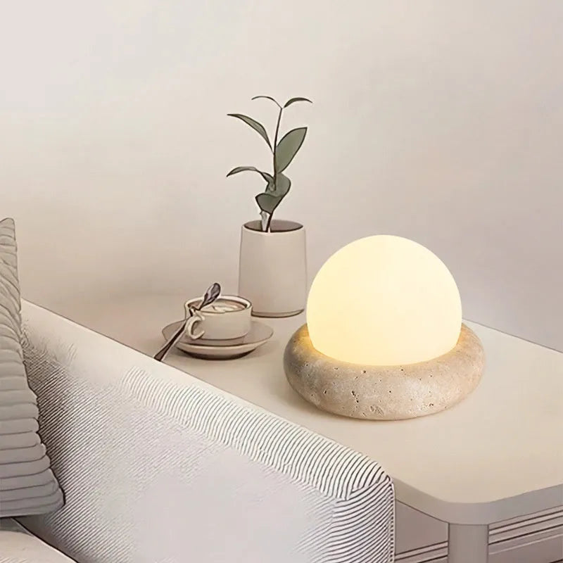 Cream coloured bedside night light with remote control on wooden table