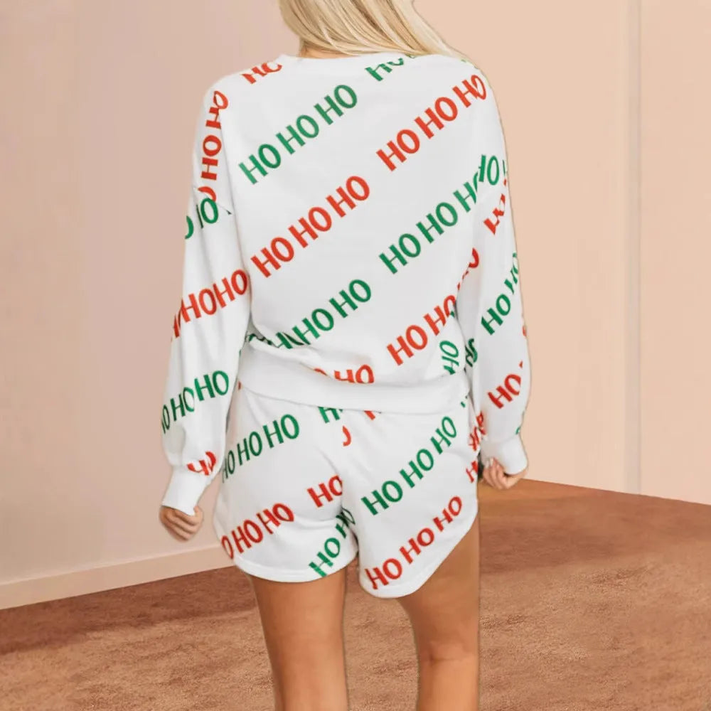 White women's two-piece suit with black letter print, long sleeves, and matching cropped pants.