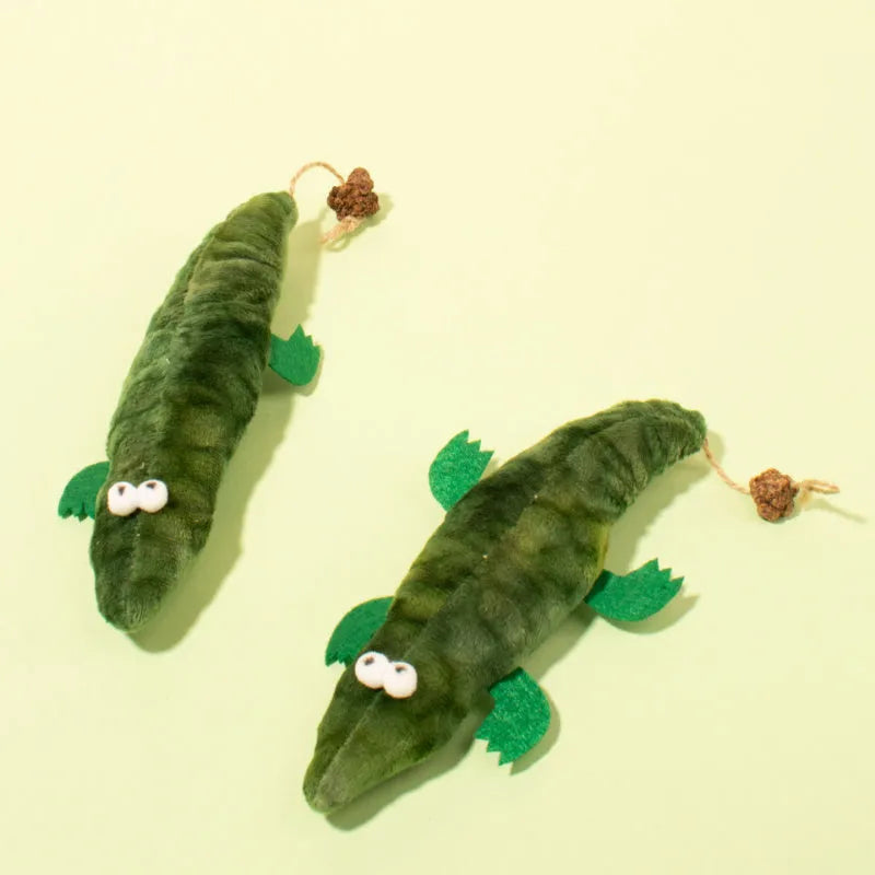Green plush alligator cat toy with a textured reptilian design on a white background.
