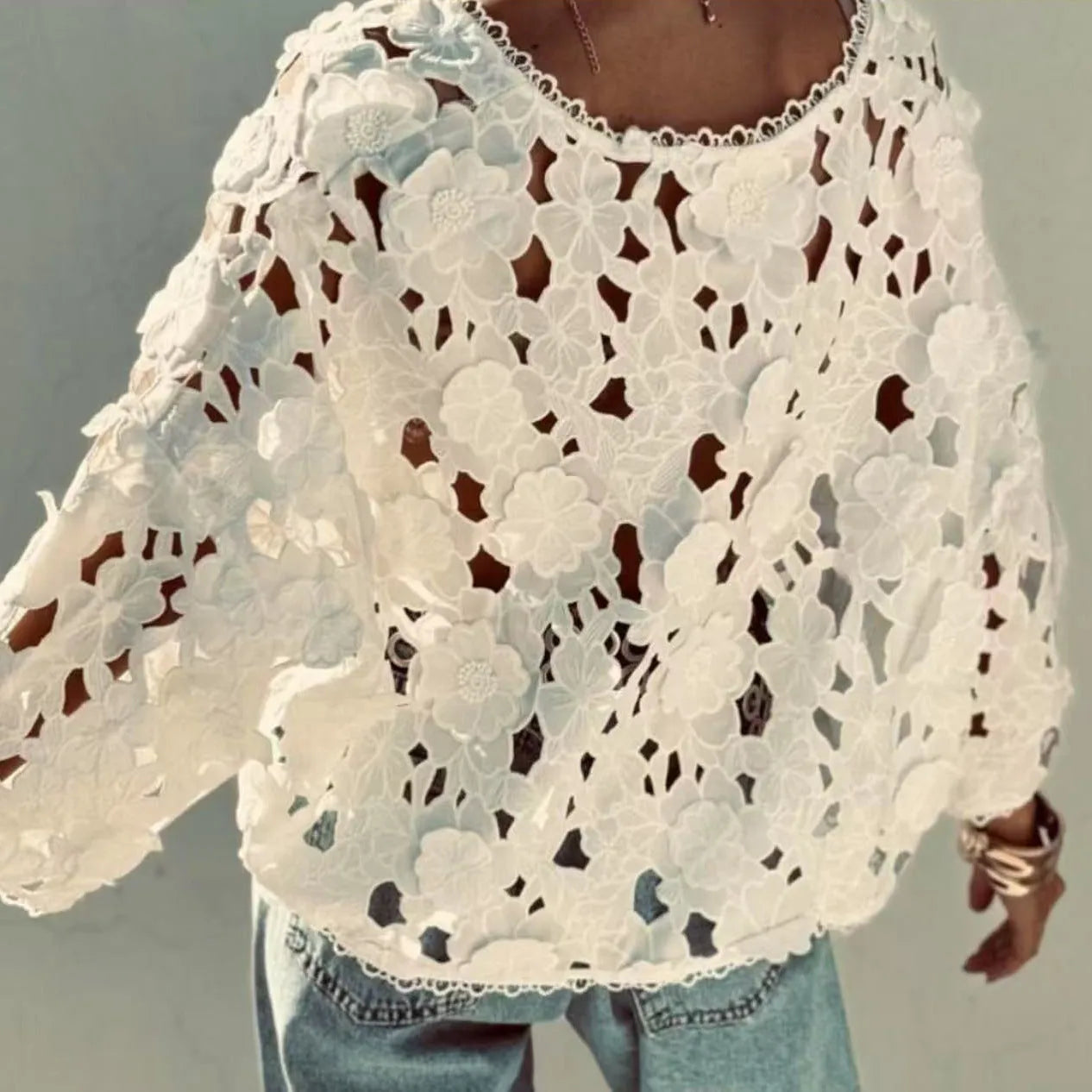 Black lace v-neck cardigan with three-dimensional white flower decorations on the sleeves.