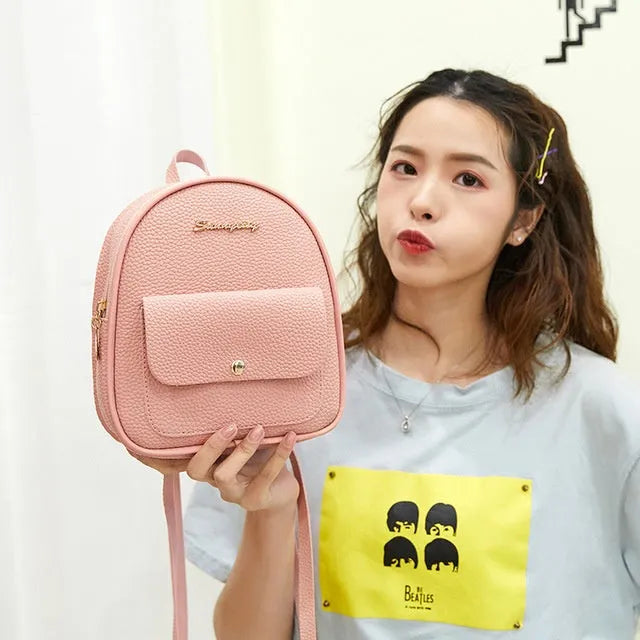 Small black PU women's backpack with shoulder strap showing compact dimensions