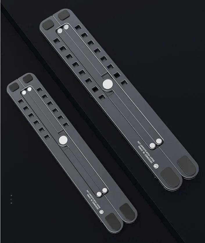 Silver foldable aluminium laptop stand holding a MacBook at an adjustable angle.