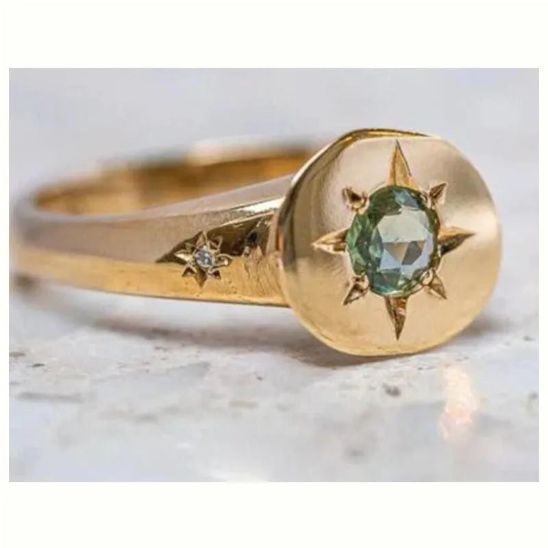 Golden star-shaped ring with oval zircon stone and adjustable band.