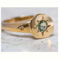 Golden star-shaped ring with oval zircon stone and adjustable band.