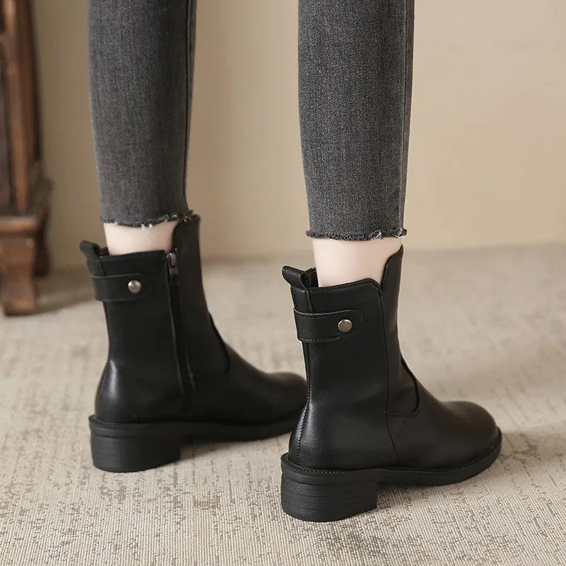 Black women's low heel ankle boots with side zip and round toe on a rubber sole.