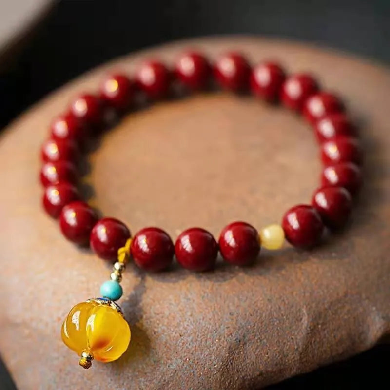 Handmade wave-shaped bracelet in cinnabar and copper beads on a wrist.