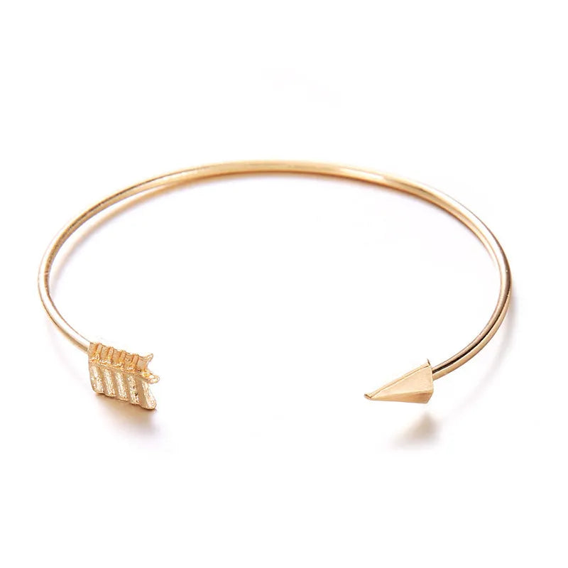 Gold electroplated alloy women's cuff bracelet with arrow and knotted design pattern