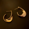 Twisted geometric metal earrings with electroplated gold or silver finish and round shape