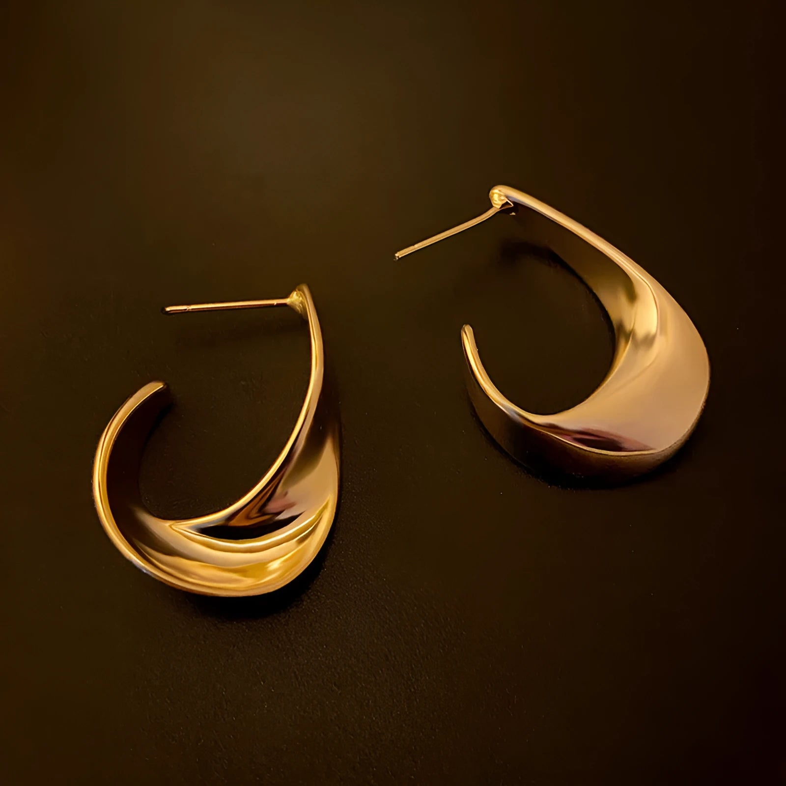 Twisted geometric metal earrings with electroplated gold or silver finish and round shape