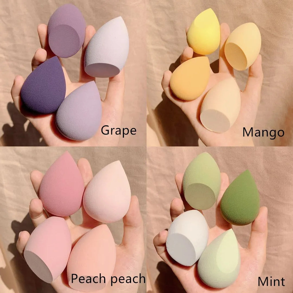 Four makeup egg sponges in grape, mango, mint, and peach peach colours, each approximately 6cm long