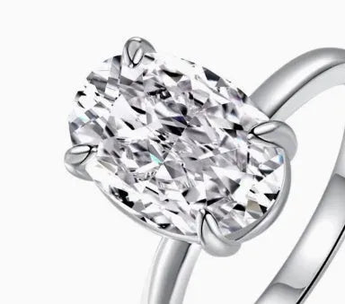 Oval women's ring in silver with four-claw setting holding a hand-cut gem.