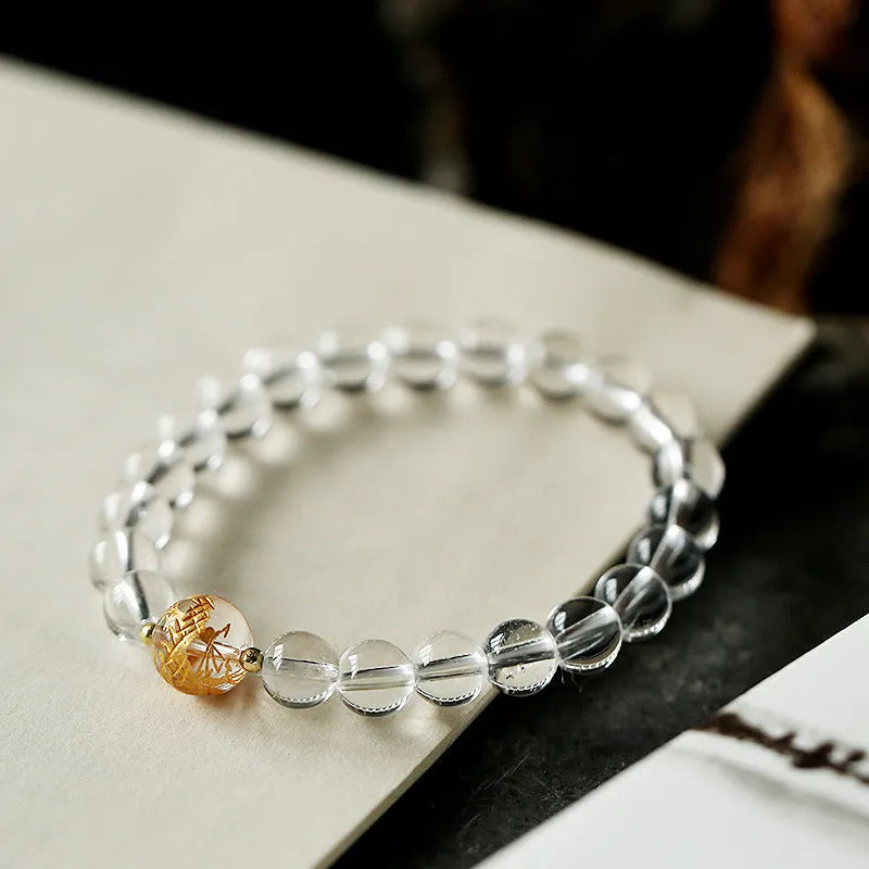 Geometric obsidian white crystal bracelet with black agate beads and gold dragon charm on wrist