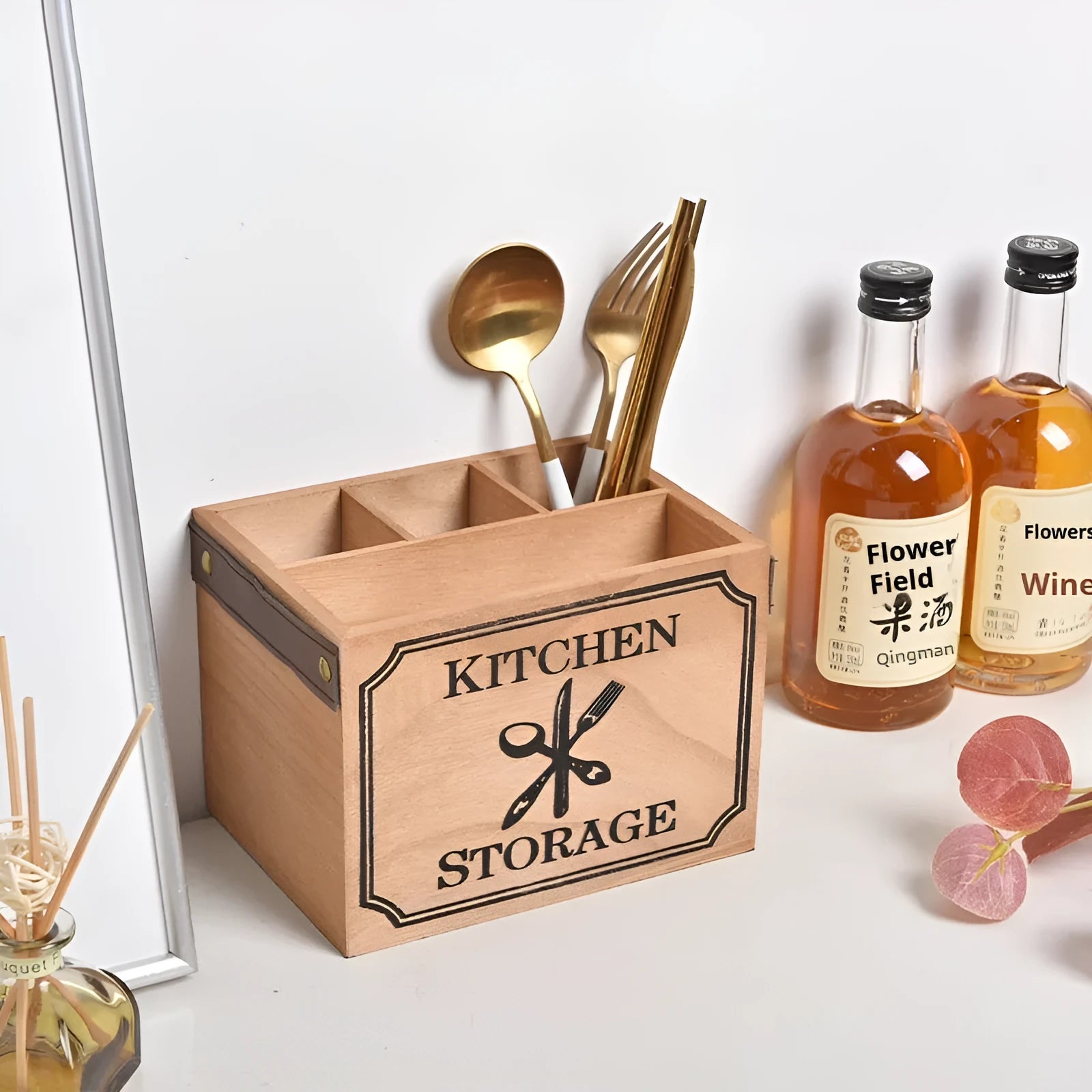 Open-top wooden kitchen storage box with internal grid divider for organising utensils.