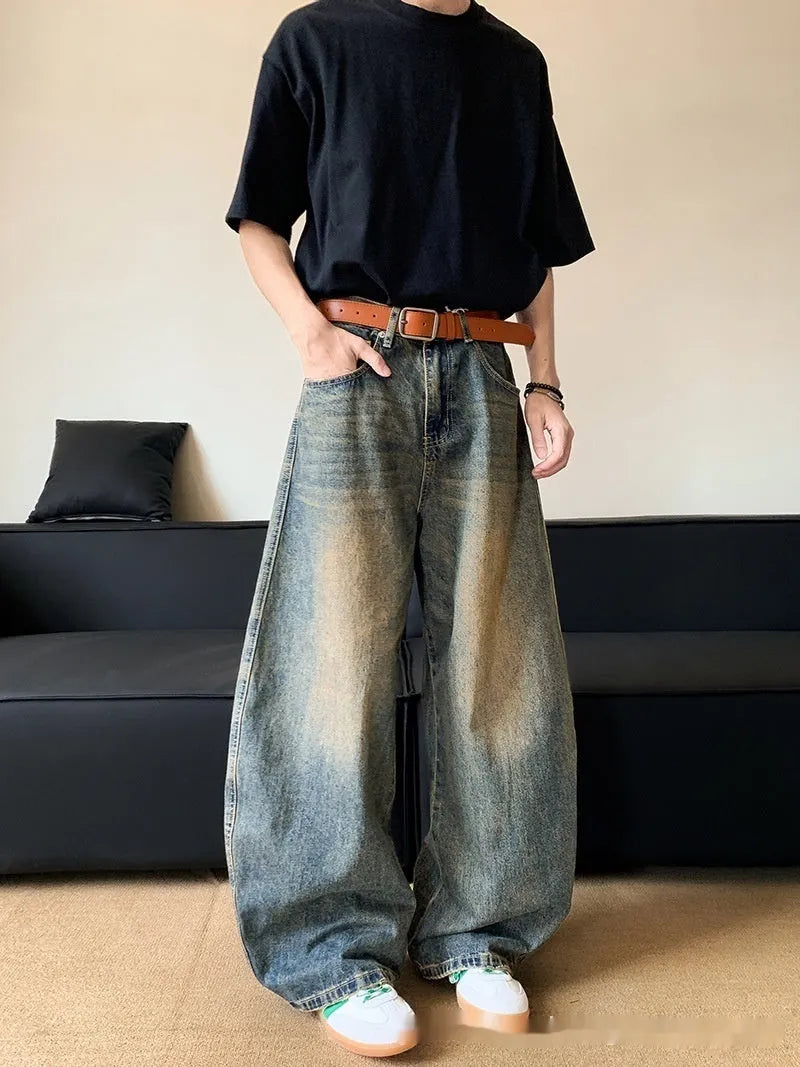 Men's distressed retro blue denim trousers with wide-leg silhouette and micro-elastic cotton-blend fabric