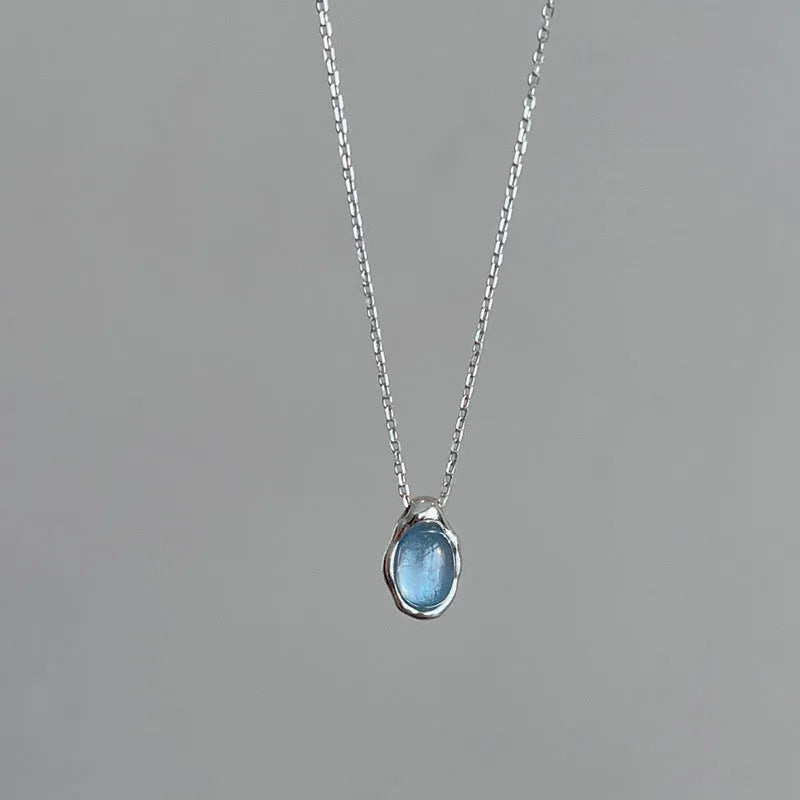 Navy blue water drop pendant necklace with adjustable chain on neutral background