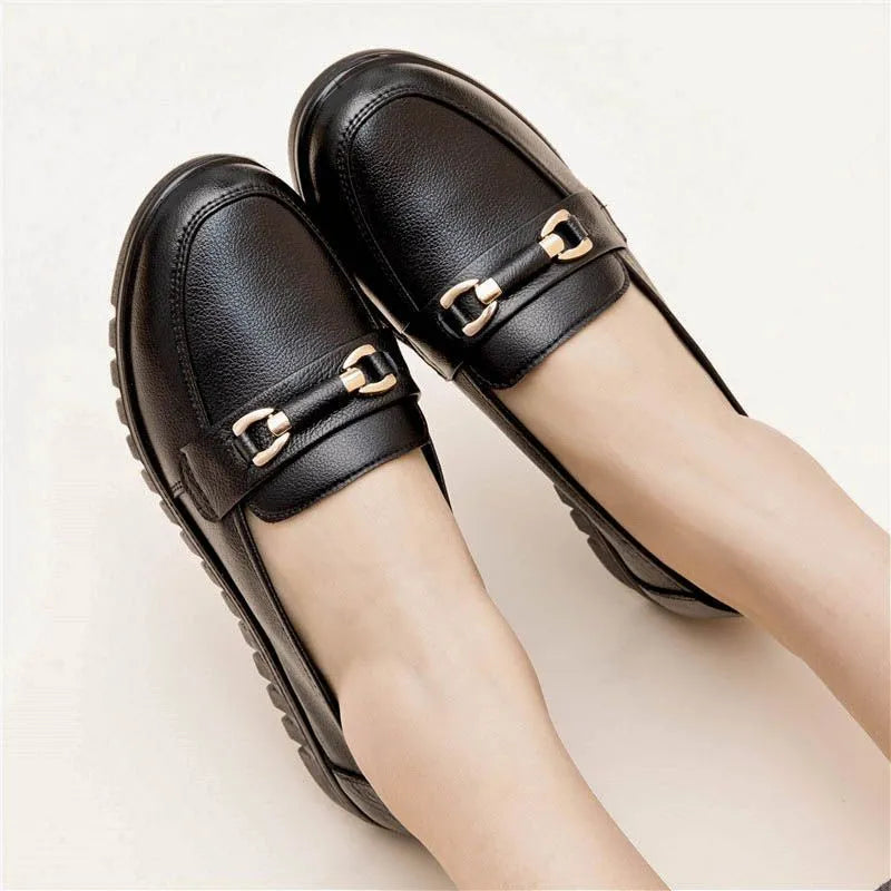 Black women's casual slip-on pumps with a round toe, low heel, and metallic detail.