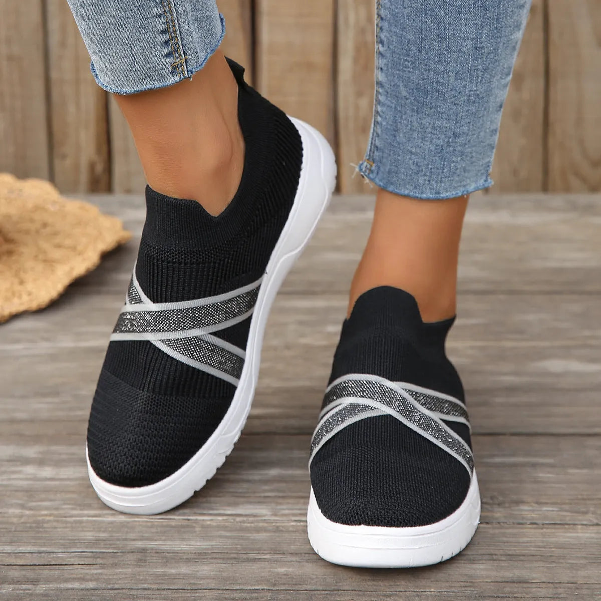 Black women's Flyknit mesh flat shoes with a tassel detail on the low-top upper and a flat rubber sole.