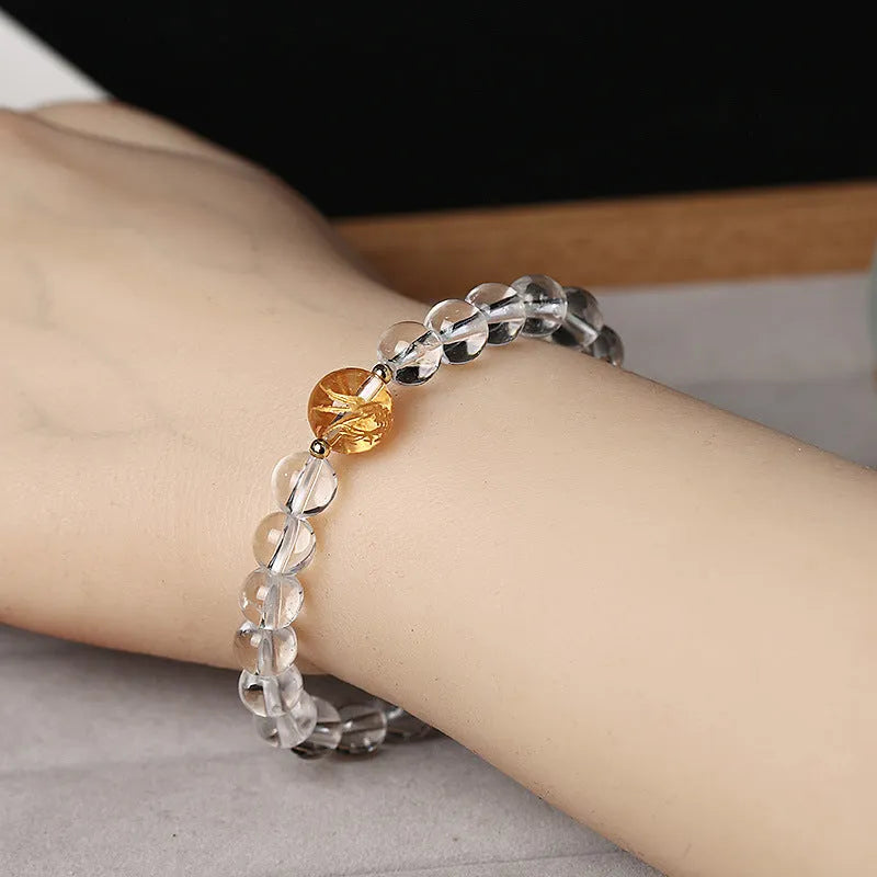 Geometric obsidian white crystal bracelet with black agate beads and gold dragon charm on wrist