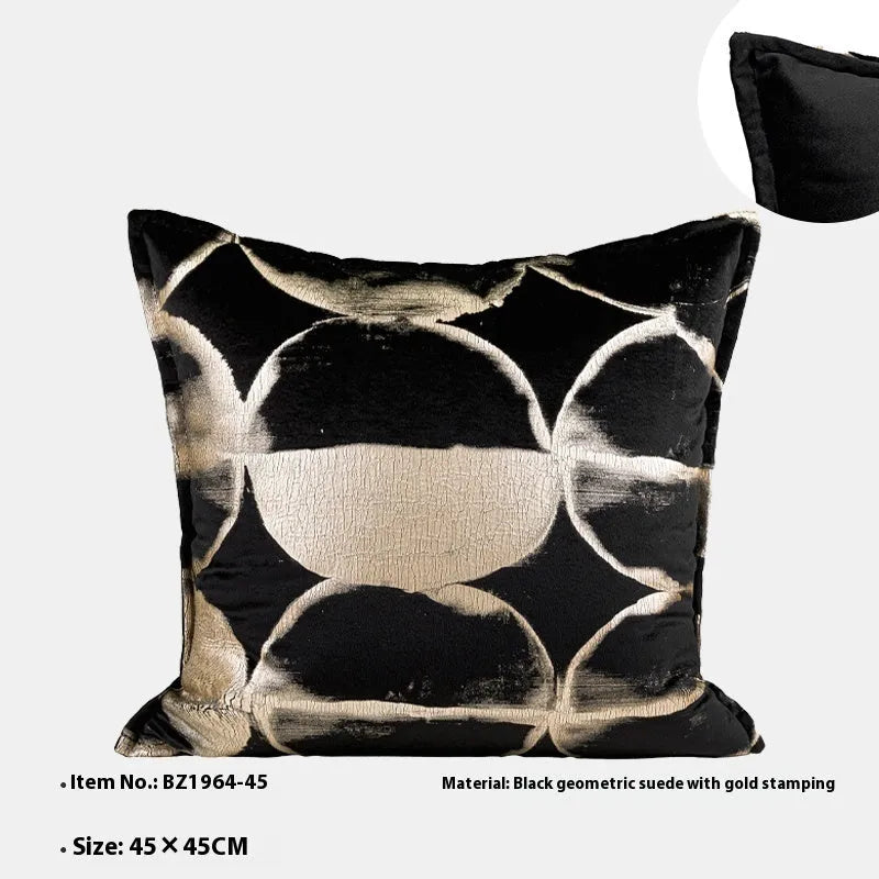 Black and gold abstract patterned flannel decorative cushion on a grey sofa.