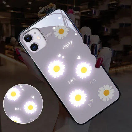 White voice-activated LED iPhone case with painted daisy and letter design, showing colour-changing lights.