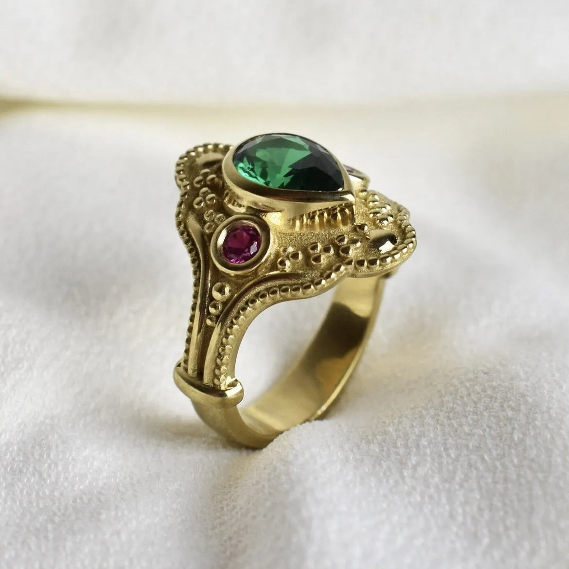 Golden geometric women's ring on a plain background, showing its alloy construction and electroplated finish.