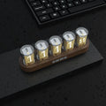 RGB LED digital tube clock showing colourful display with black plastic casing on wooden desk