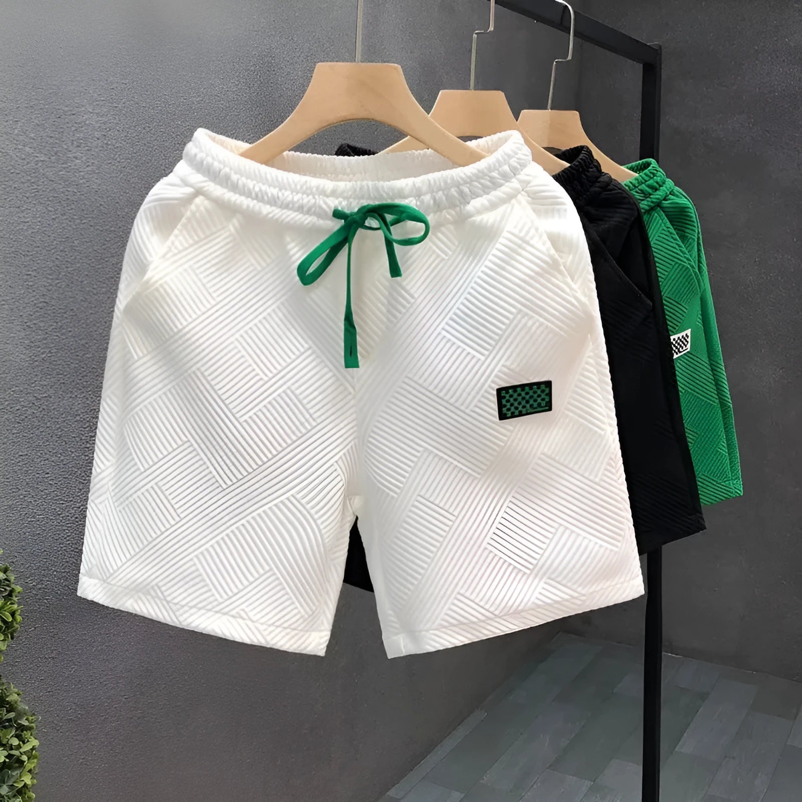Solid colour polyester sports shorts with elastic waist on a mannequin, shown in black.