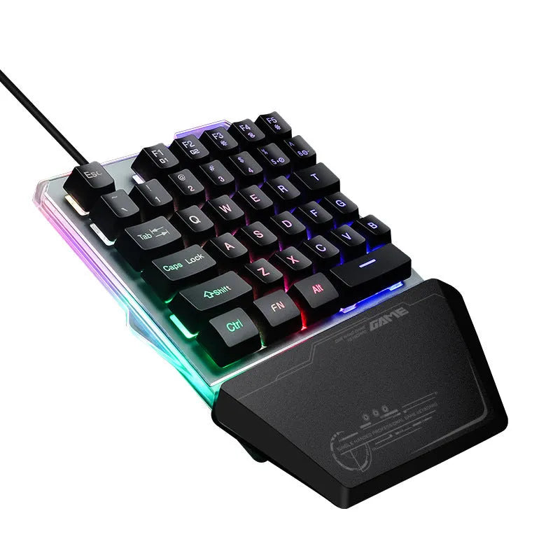 Black one-handed robotic gaming keyboard with RGB backlit keys on a desk.