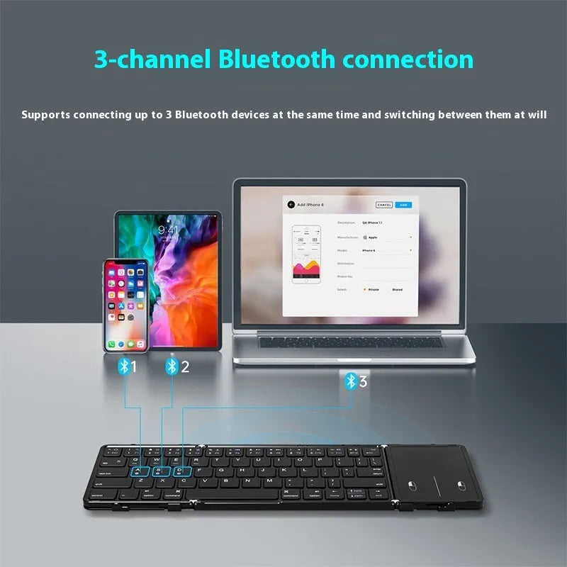 Black folding Bluetooth keyboard with touchpad unfolded next to mobile phone
