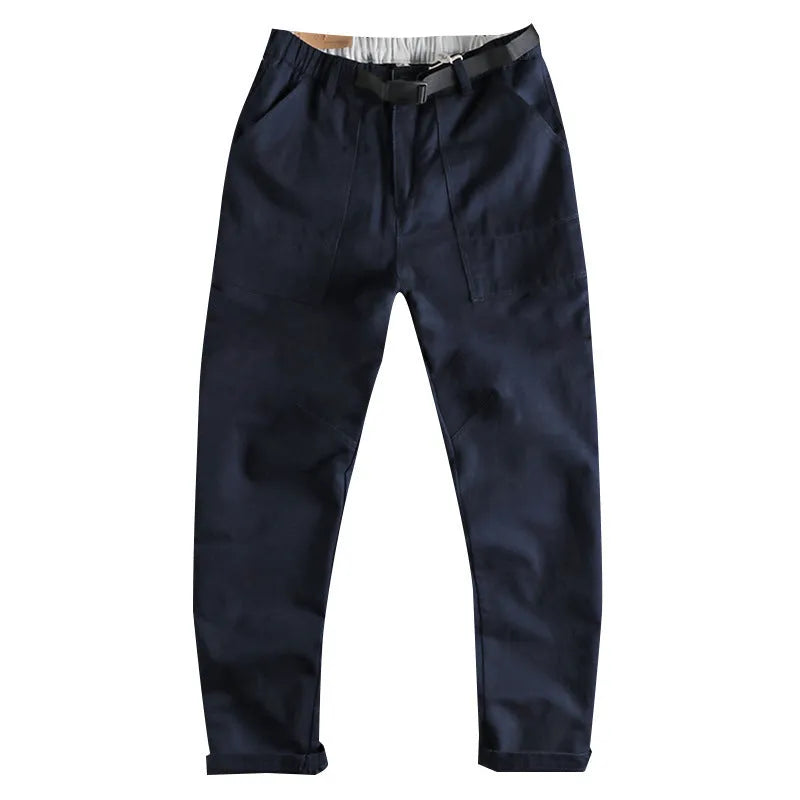 Men's khaki cotton work trousers with an N I buckle belt on a mid waist.