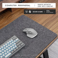 Simple grey felt and cork desk mat in an oversized rectangle shape on a wooden desk.