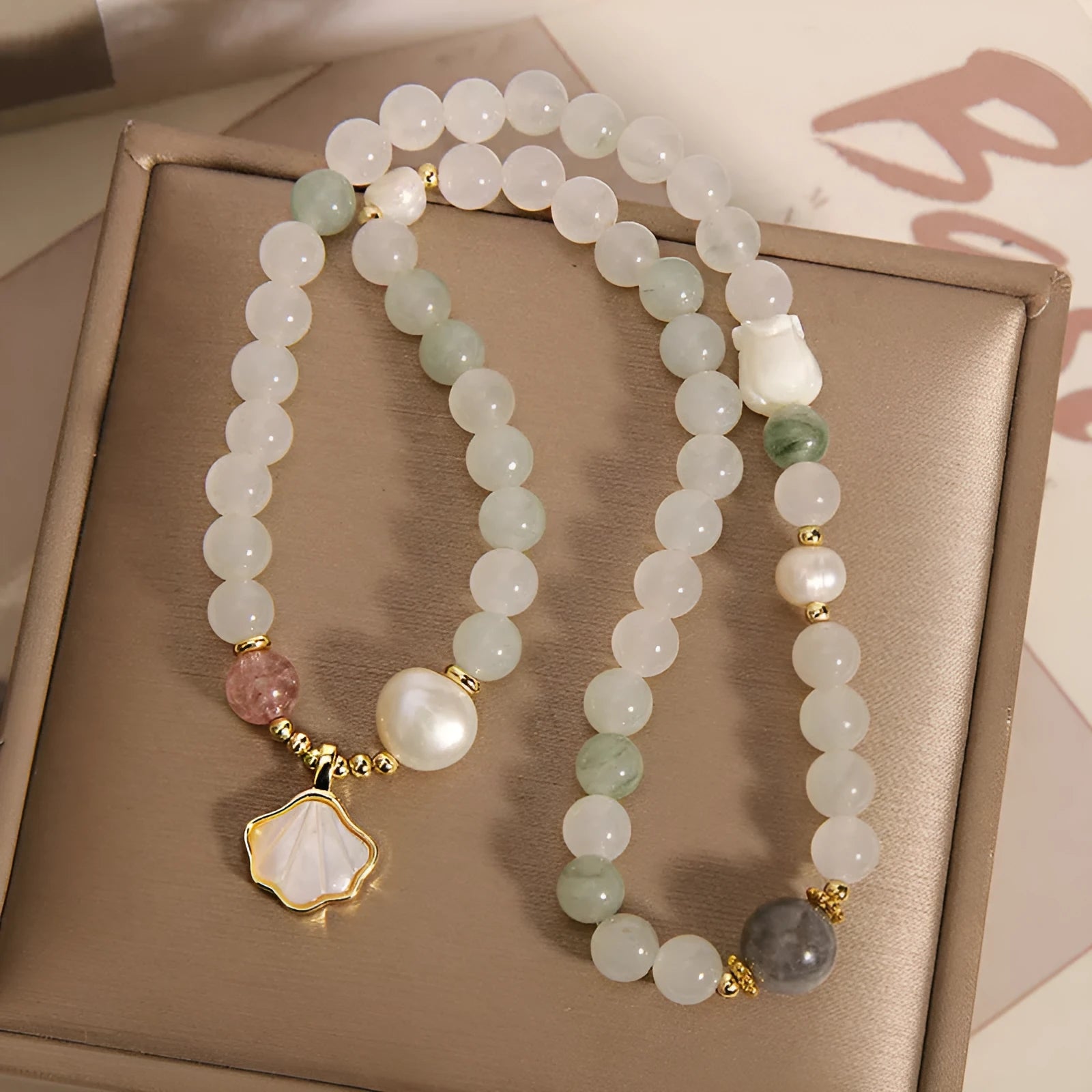 Women's crystal bracelet with a gold-plated ginkgo leaf pendant and rhinestone details.