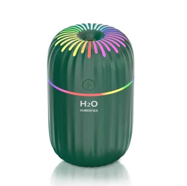White USB mini humidifier with water tank on desk next to laptop
