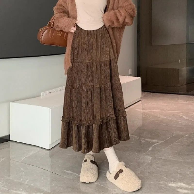 Korean-style beige corduroy A-line midi skirt with an elastic waistband laid flat.