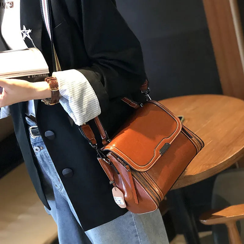 Genuine leather women's retro messenger bag in brown, showing internal organiser pockets and shoulder strap.