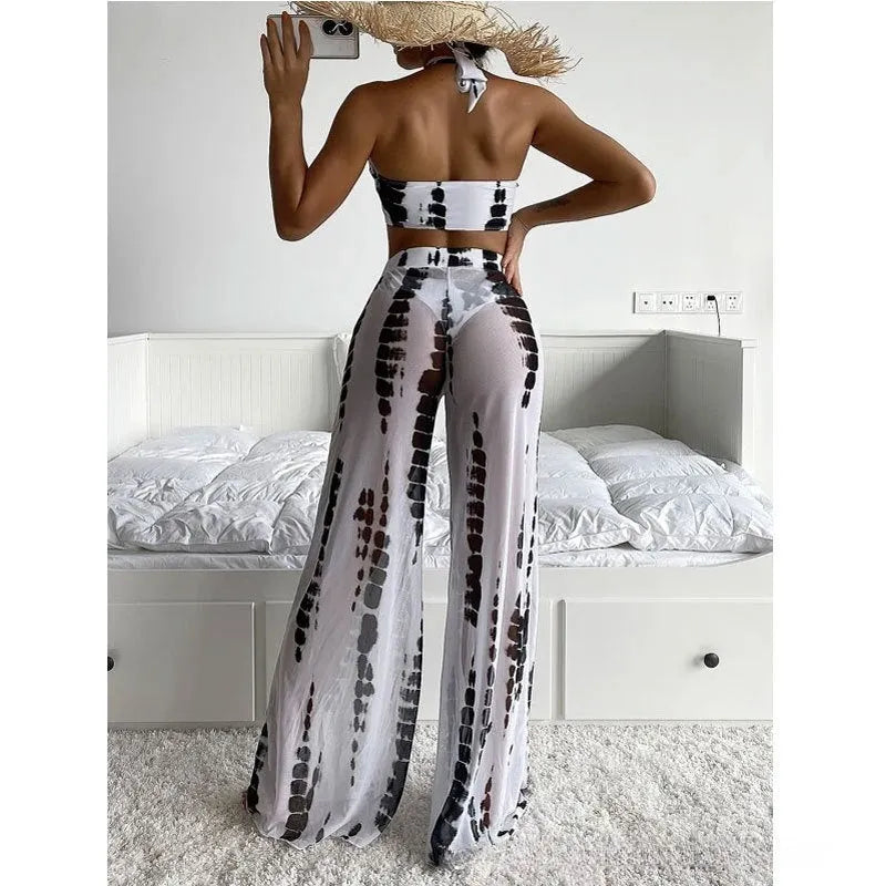 Women's black printed three-piece swimsuit set showing top, bikini bottoms, and mesh trousers.