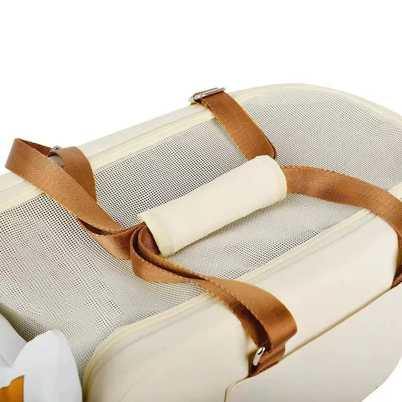 Hard-sided beige pet carrier with shoulder strap for cats and small dogs