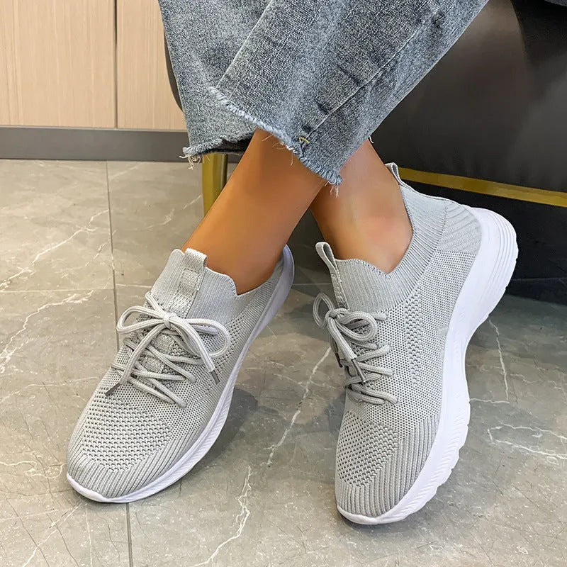 Women's low-top mesh running shoes in milky white with flyknit upper and flat rubber sole
